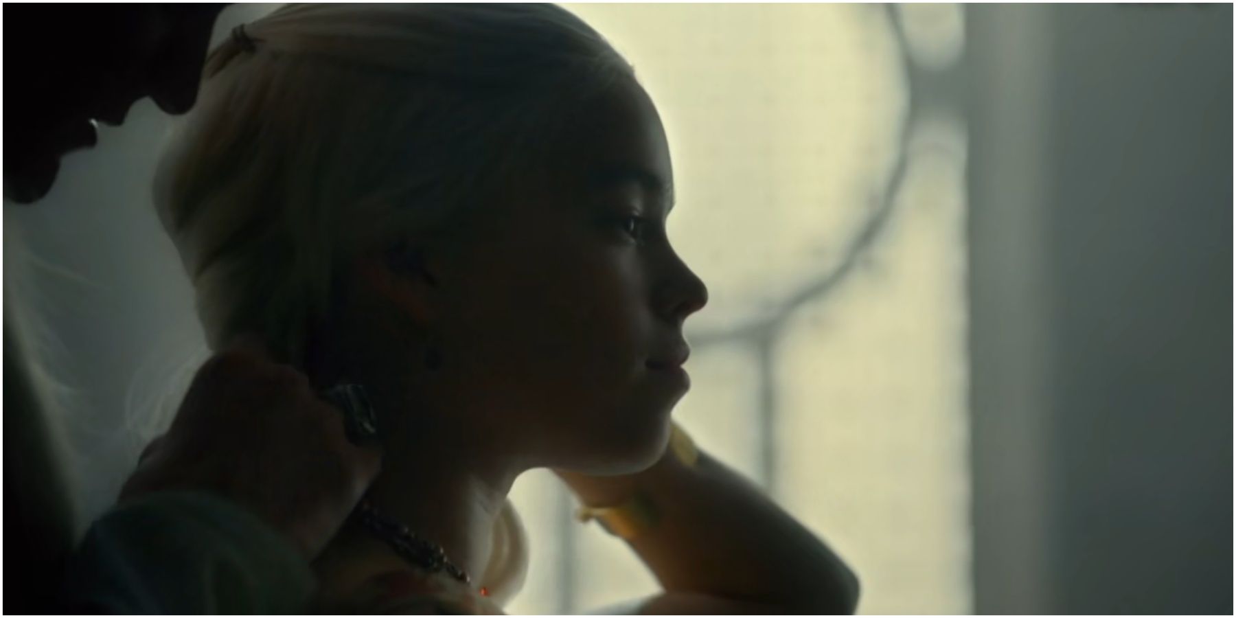 Daemon places a Valyrian steel necklace around Rhaenyra's neck in House of the Dragon.