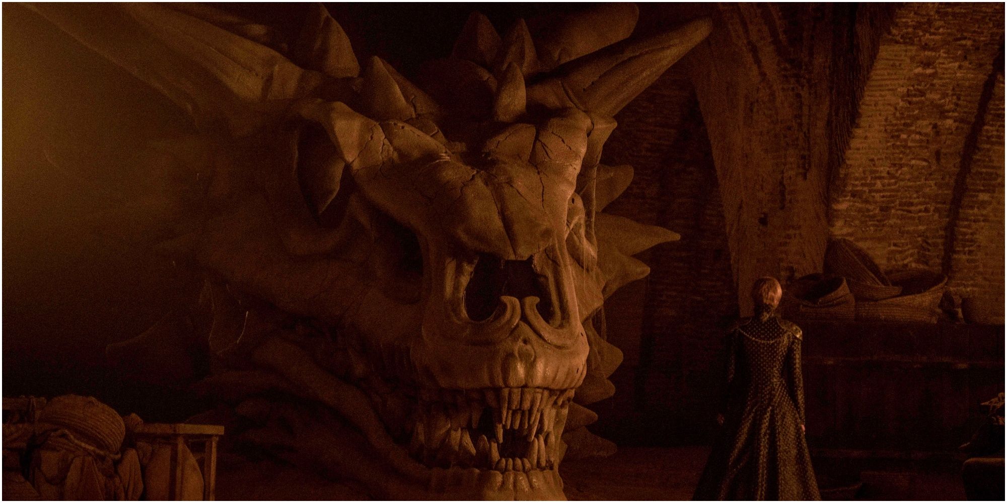 Cersei Lannister stands in front of Balerion's skull in Game of Thrones.