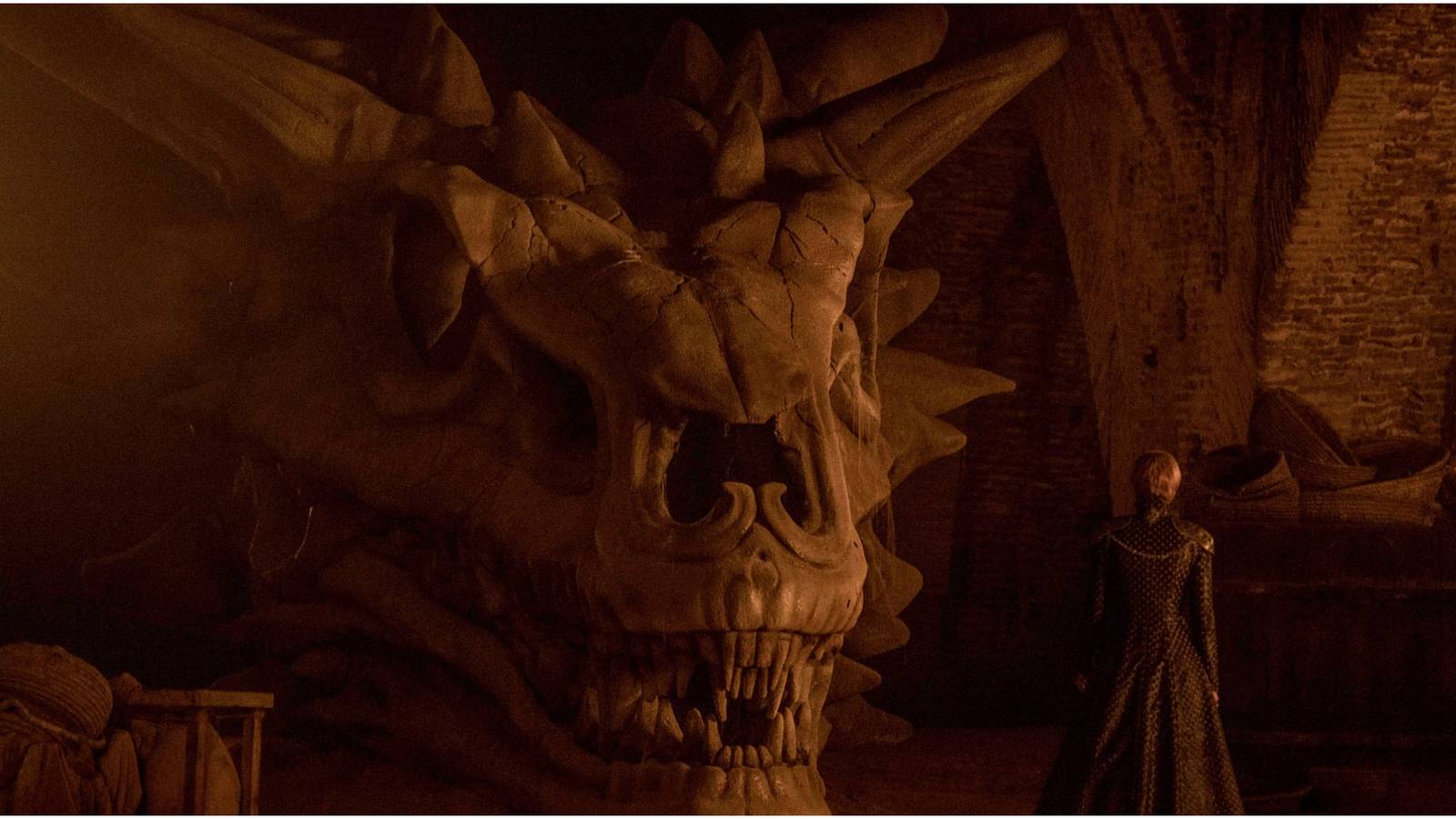 Cersei Lannister stands in front of Balerion's skull in Game of Thrones.