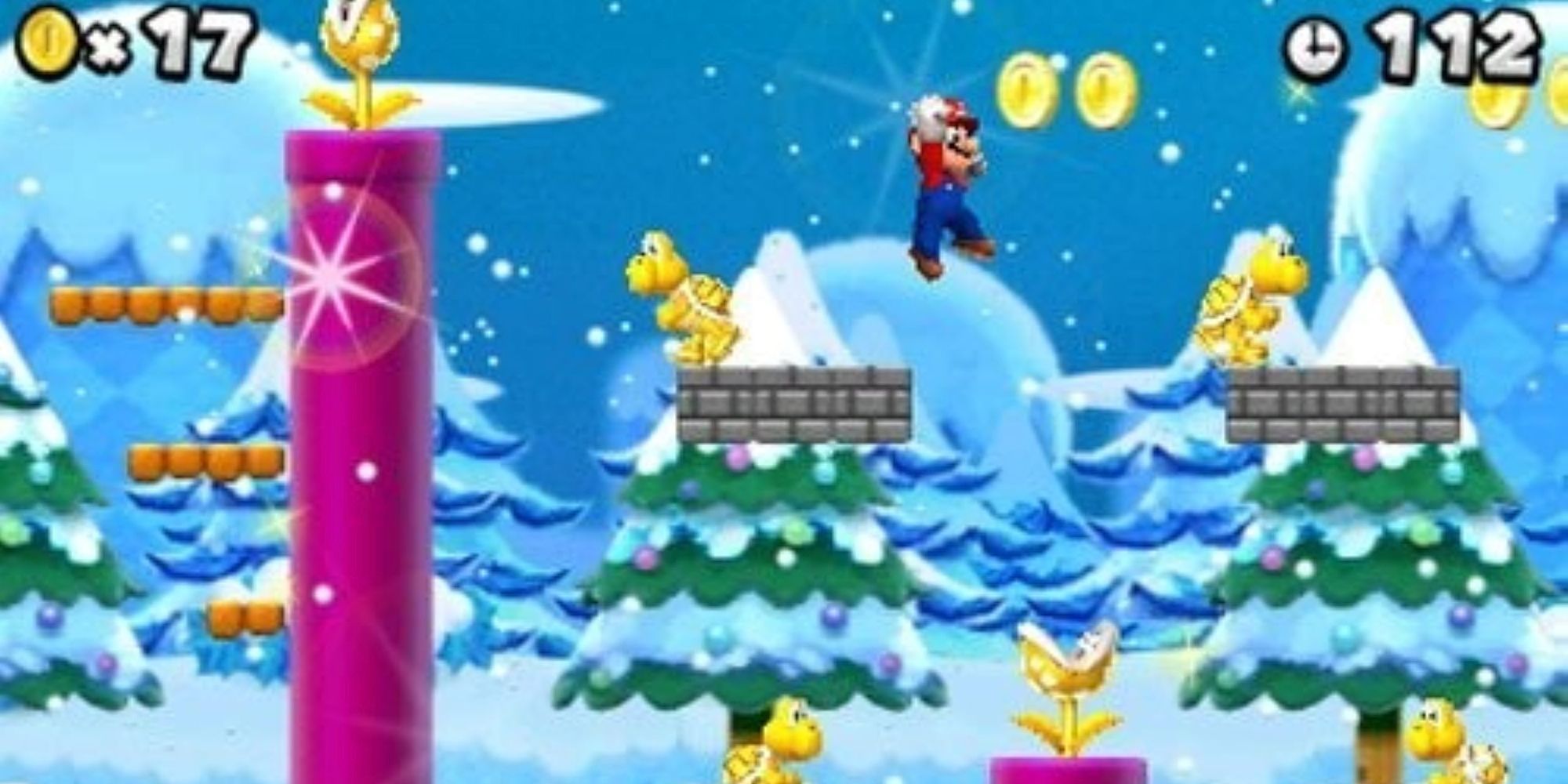 Mario jumping over gold enemies in a snow level