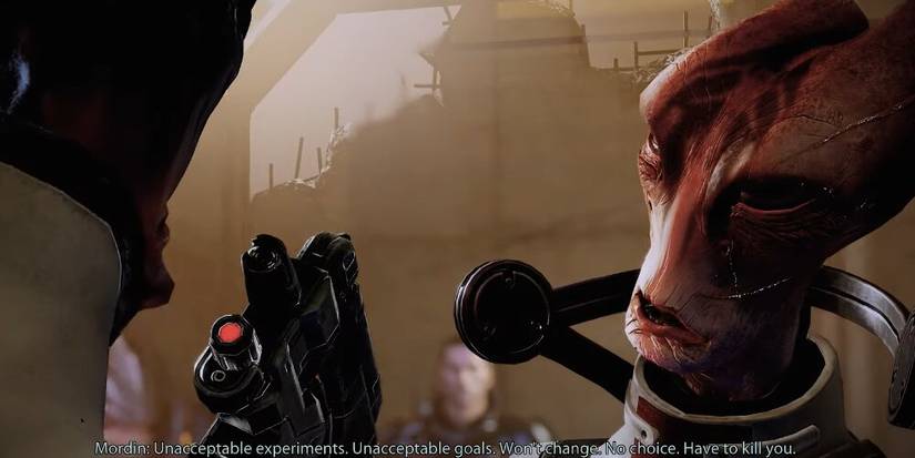Mordin aiming a pistol at his student 