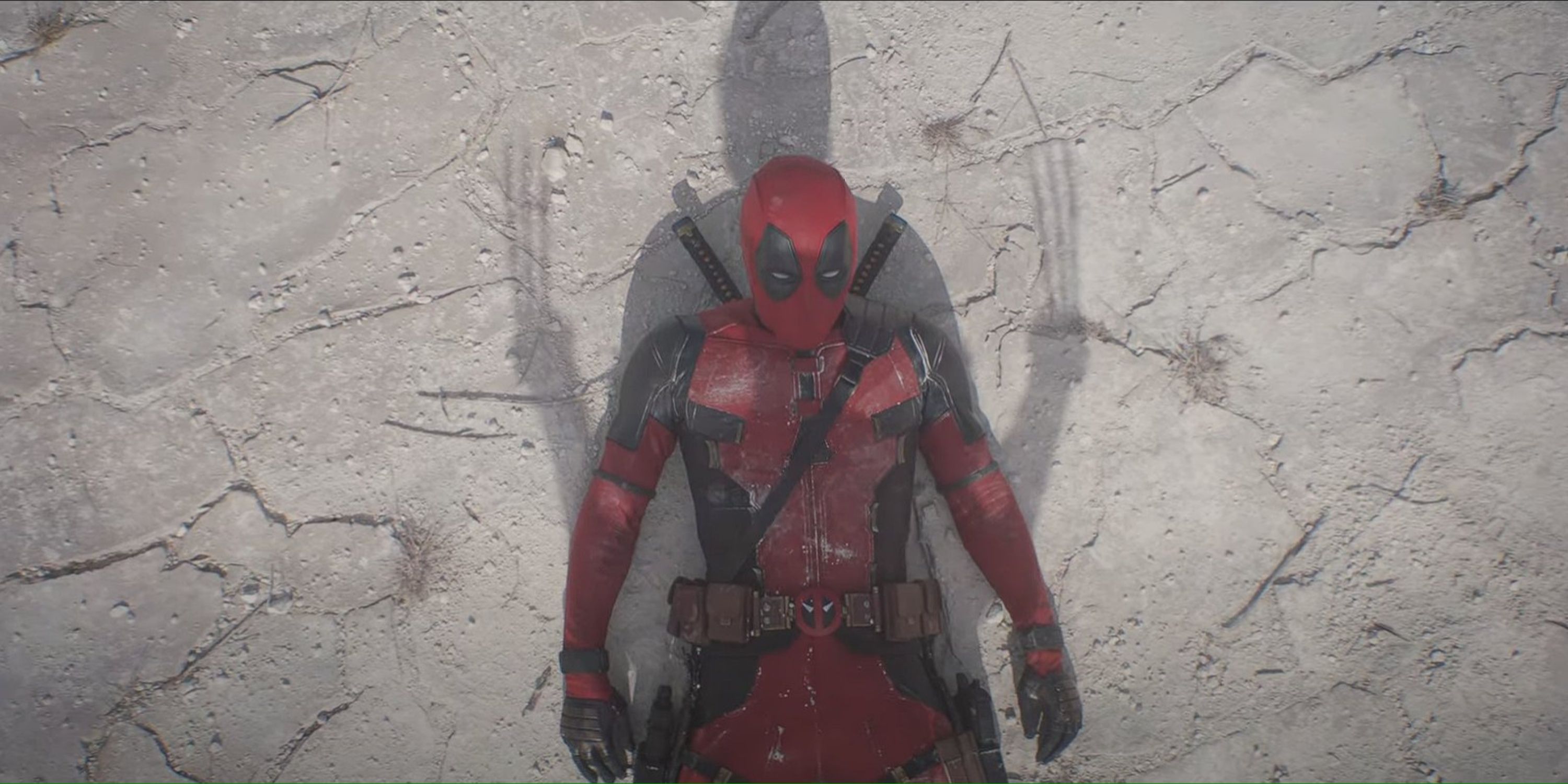 deadpool on the floor with wolverine's shadow over him