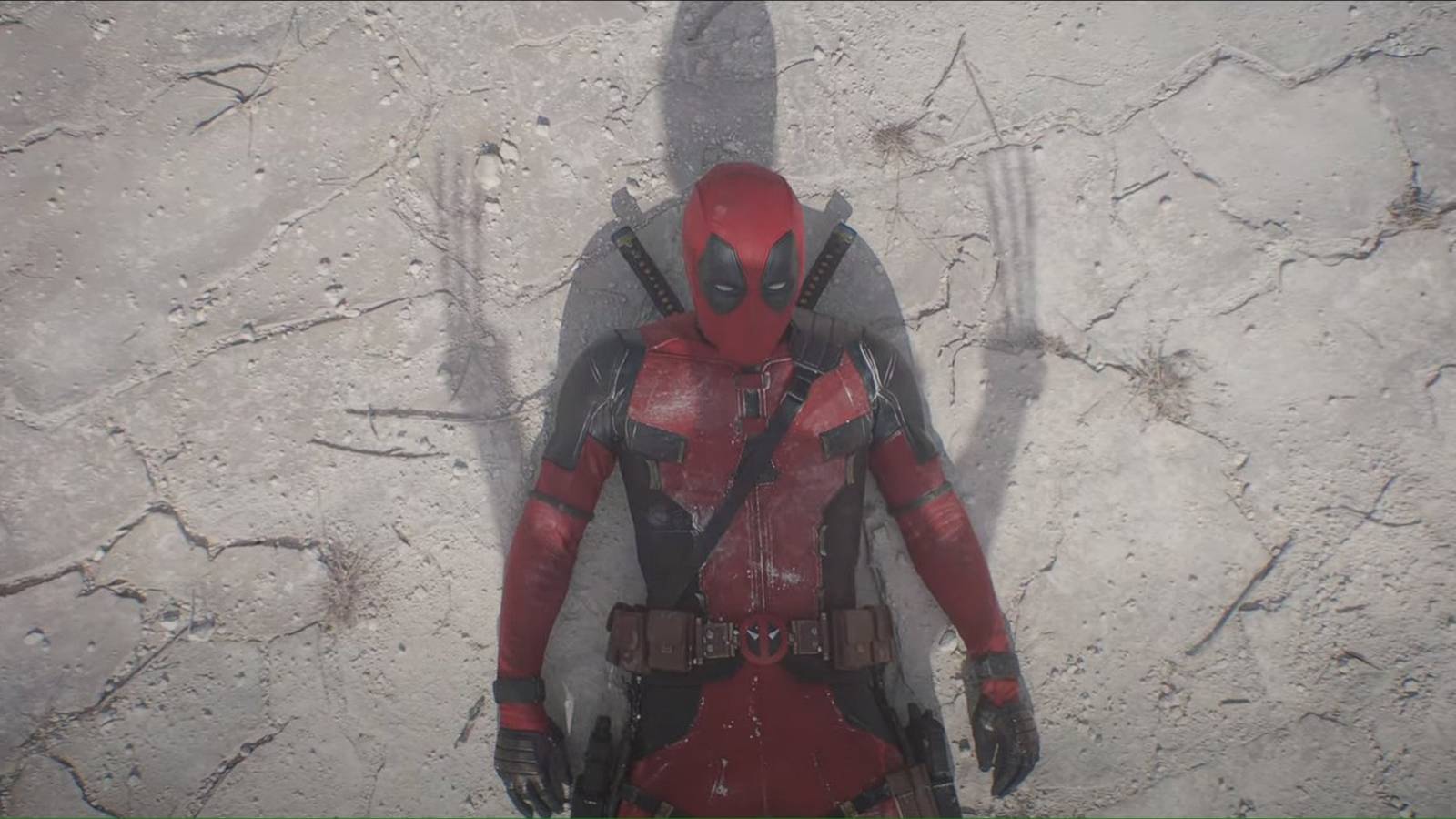 deadpool on the floor with wolverine's shadow over him