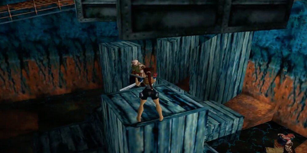 Lara standing on a tower of boxes with enemies all around her 