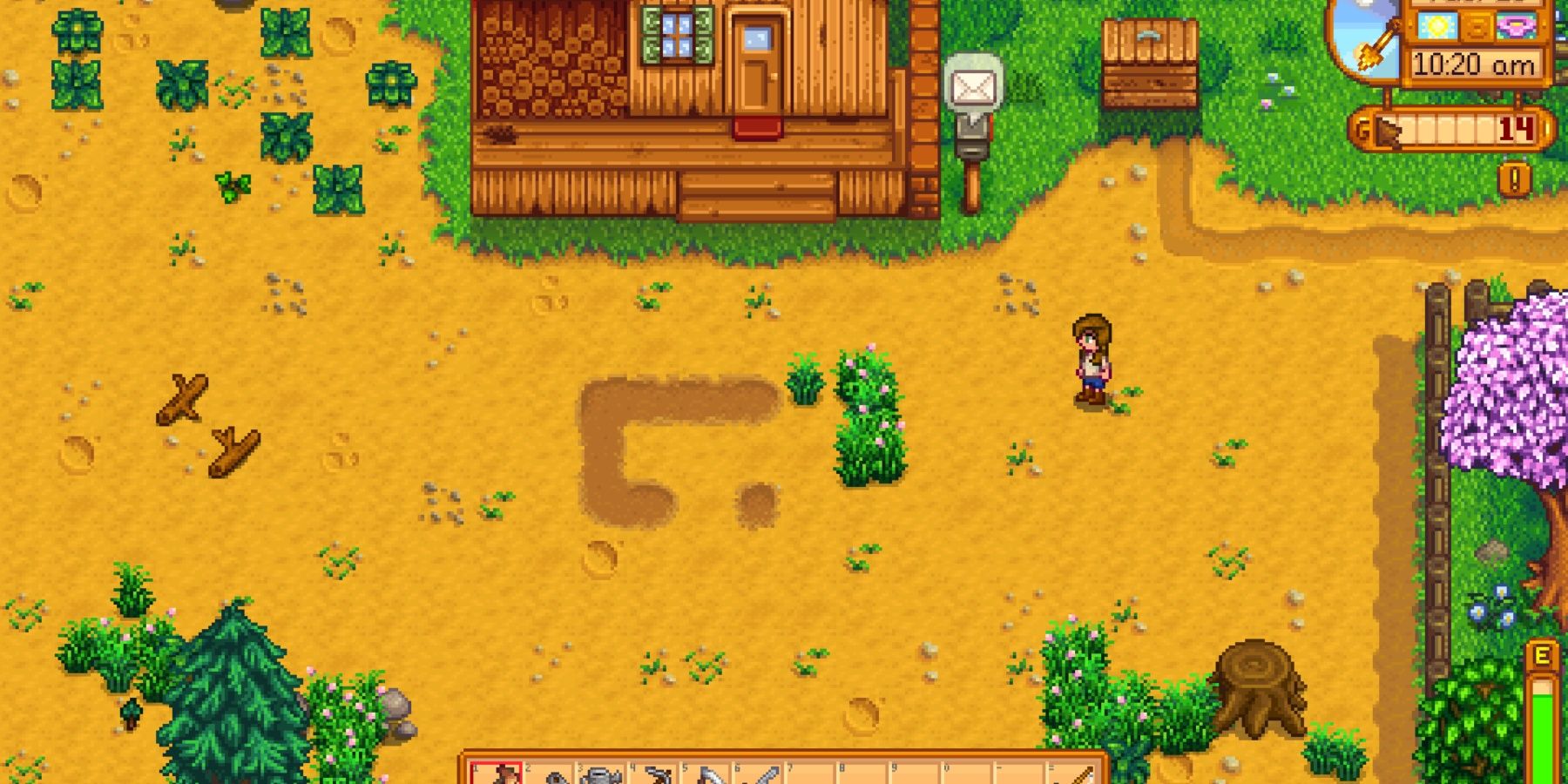 The player standing on a clear section of farm in Stardew Valley