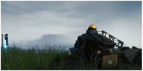 Death Stranding main character driving on grassland looking at rainbow