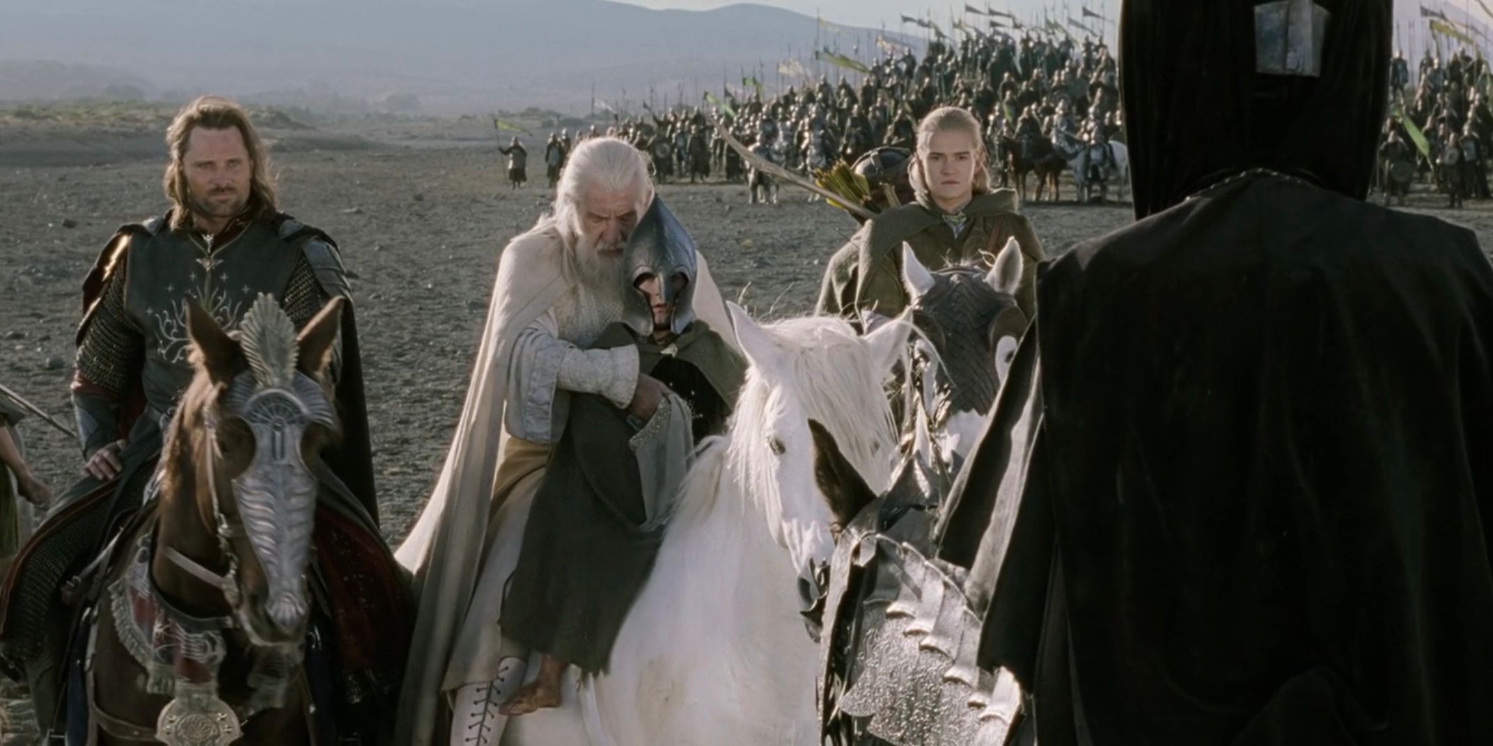 Aragorn, Gandalf, Pippin, and Legolas on horses facing the Mouth of Sauron