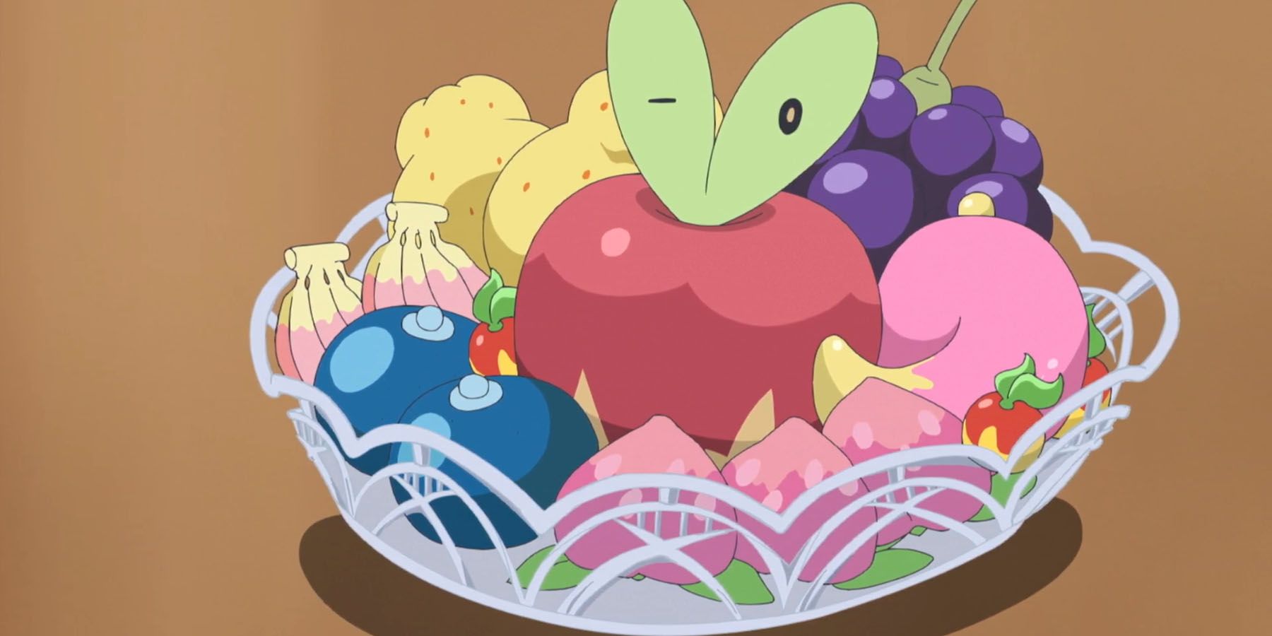 A screenshot of Applin hiding in a bowl of fruit in the Pokemon anime.