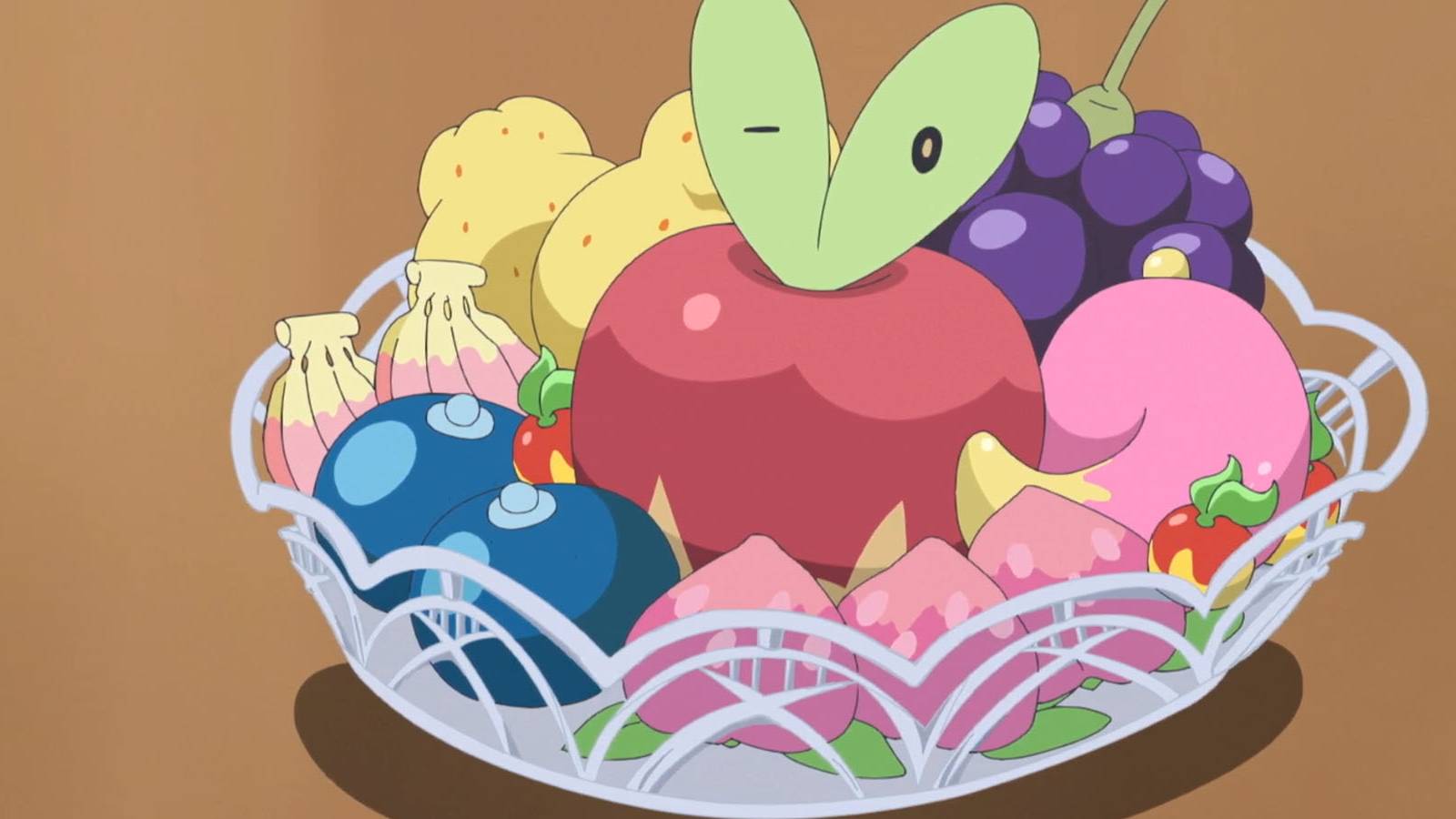 A screenshot of Applin hiding in a bowl of fruit in the Pokemon anime.