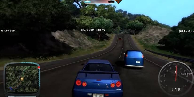 Blue car driving beside a blue van 