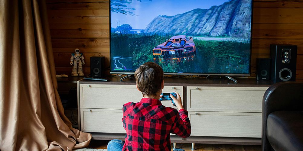 Person playing GTA V on PS4 with a TV