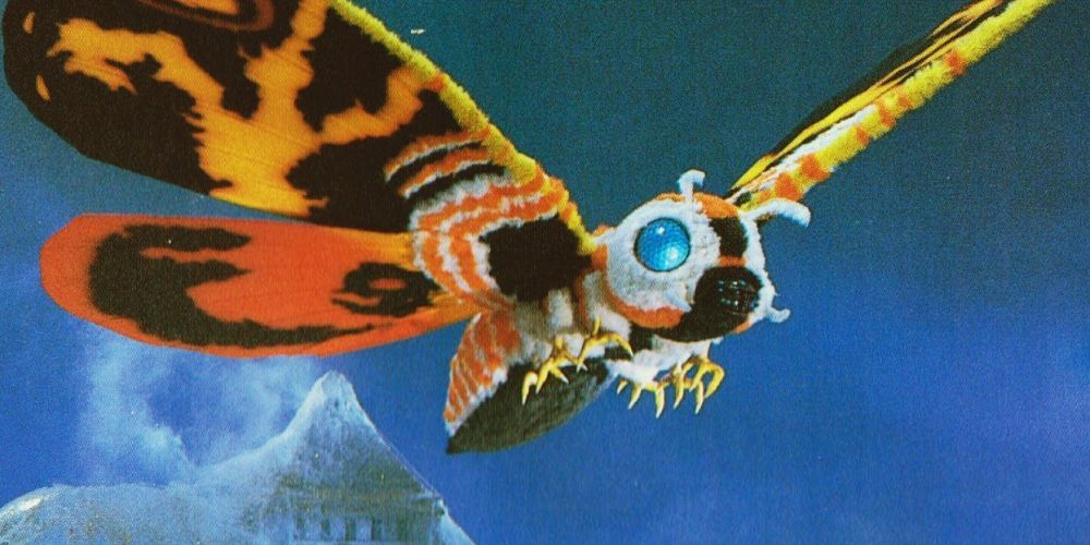 Promotional image of Mothra in her Imago form emerging from her coccoon.