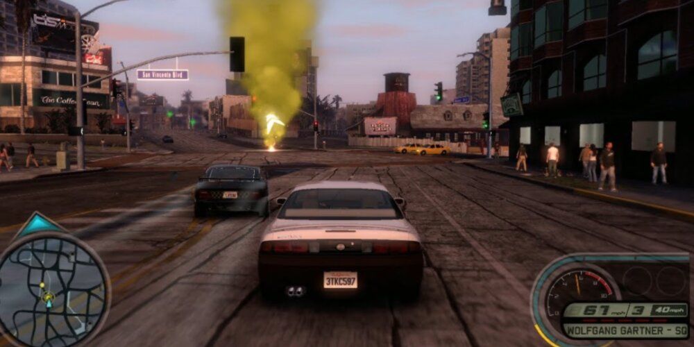 Silver car racing through a street towards a large yellow flare 