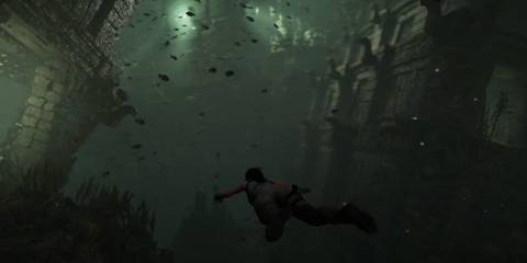 Lara Croft swimming underwater with fish all around her in Shadow of the Tomb Raider