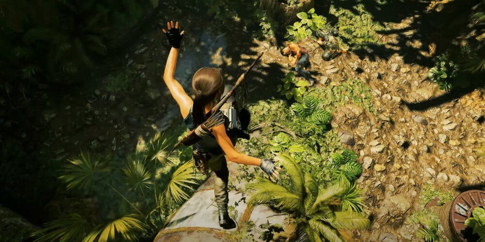 Lara falling onto a grassy surface after jumping from a tree 