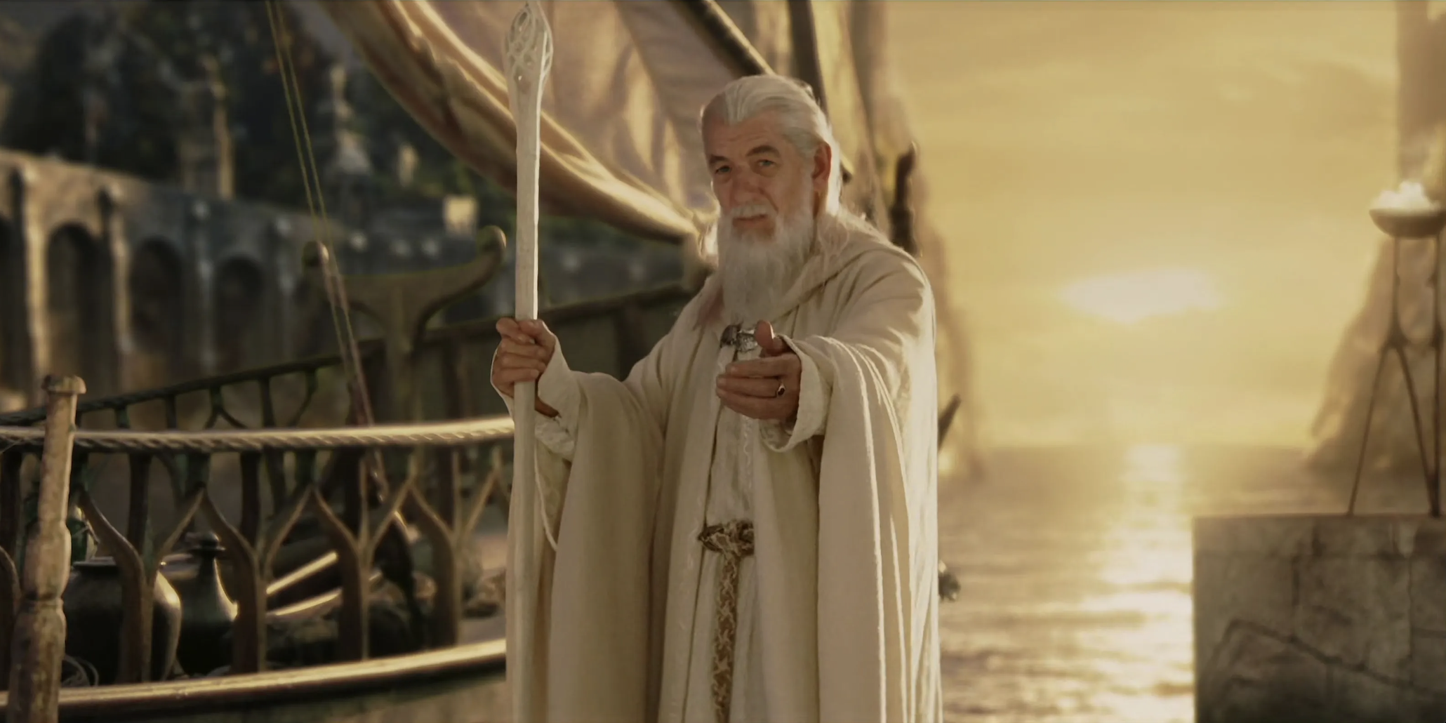 Gandalf in white robe with his hand out in LOTR