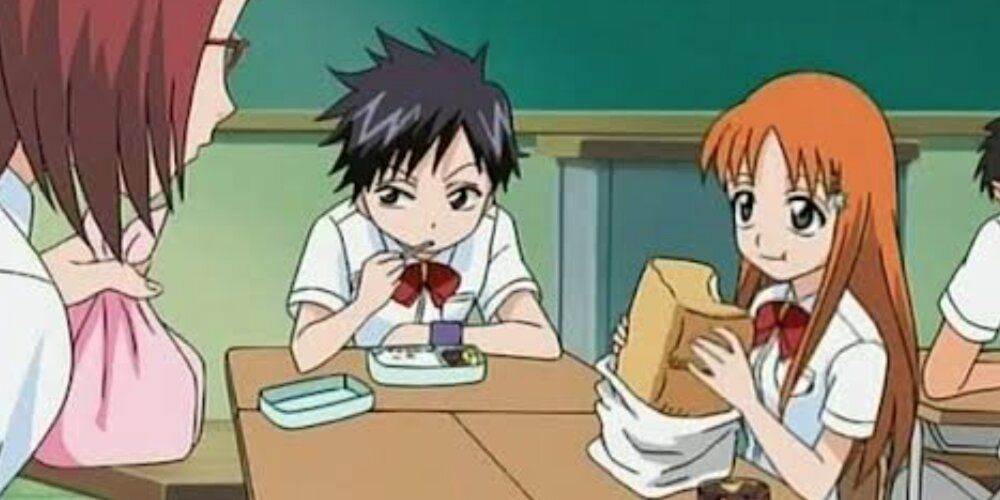 Orihime eating a block of bread next to Tatsuki on a school table 