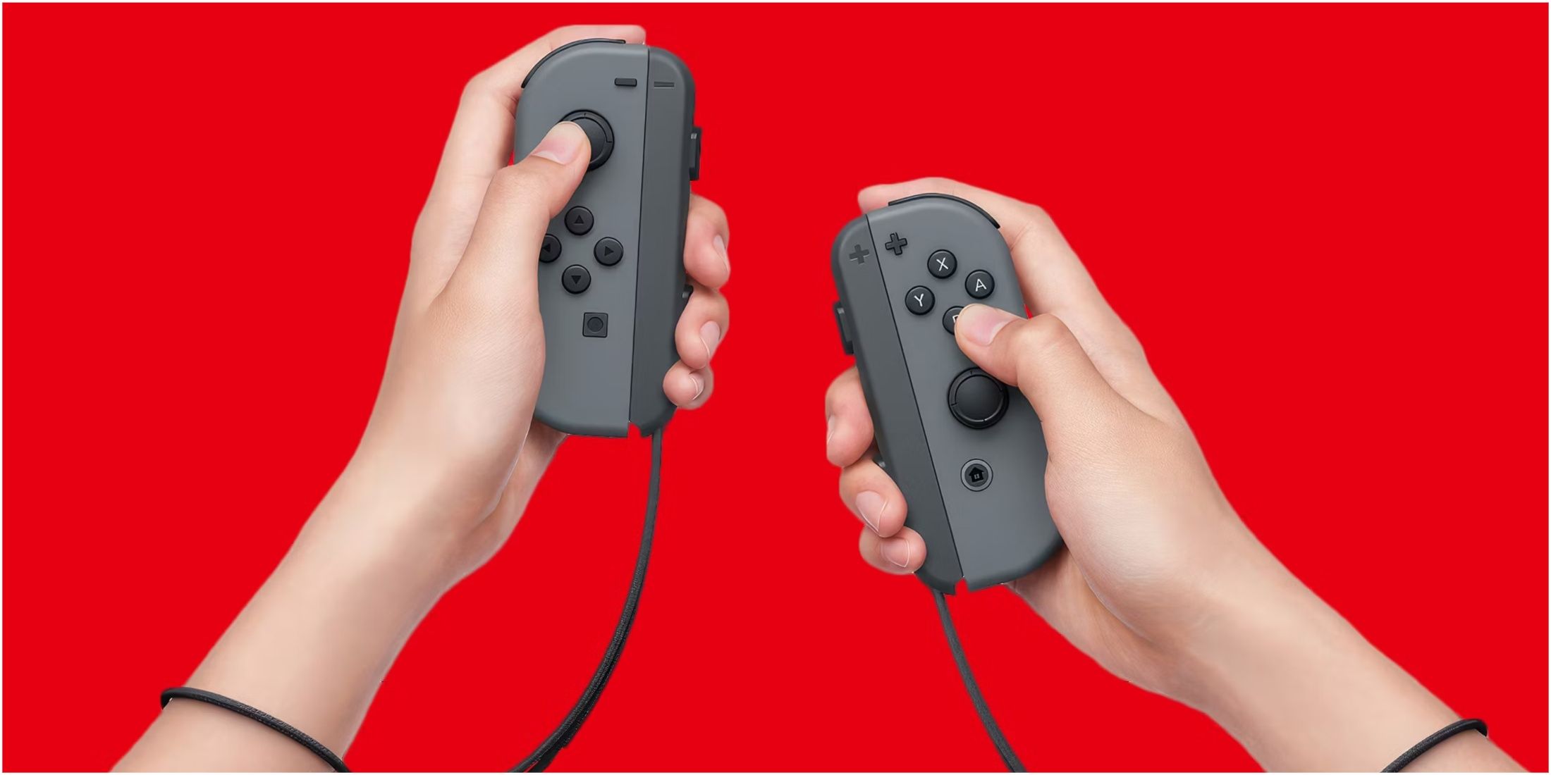 Hands holding a pair of Nintendo Switch Joycons