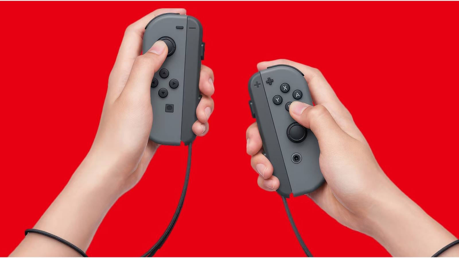 Hands holding a pair of Nintendo Switch Joycons