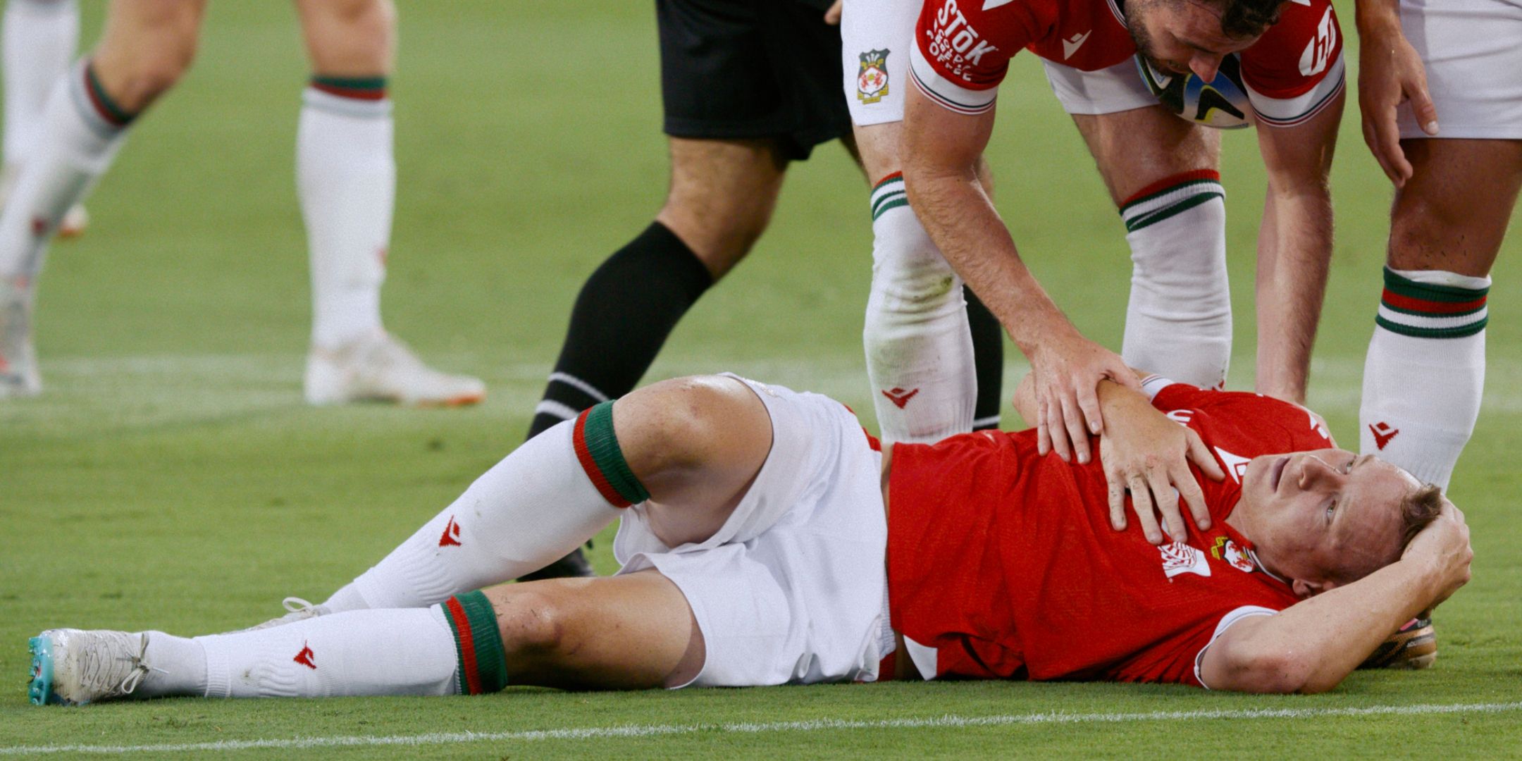 Wrexham star Paul Mullin lying on the ground with broken rib injury