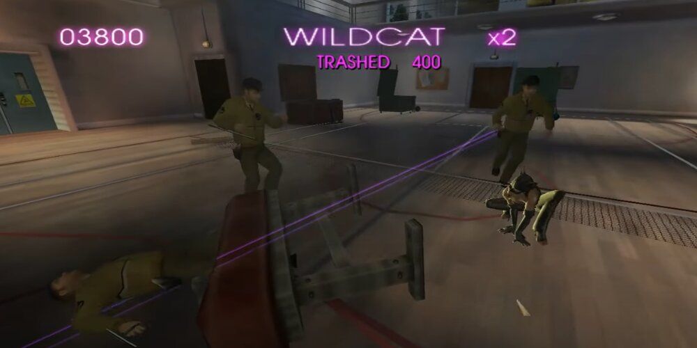 Catwoman crouching down while surrounded by guards in a school gym in the Catwoman game