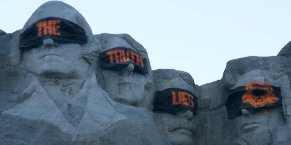 Mount Rushmore covered with graffiti with the words "The Truth Lies"