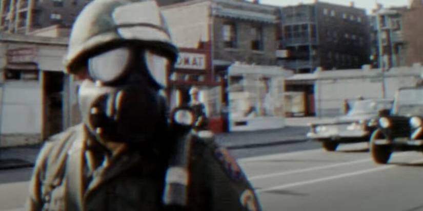 Man with a gas mask walking through a street with cars in the background 