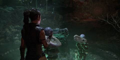 Senua standing at a stone pedestal in Hellblade 2