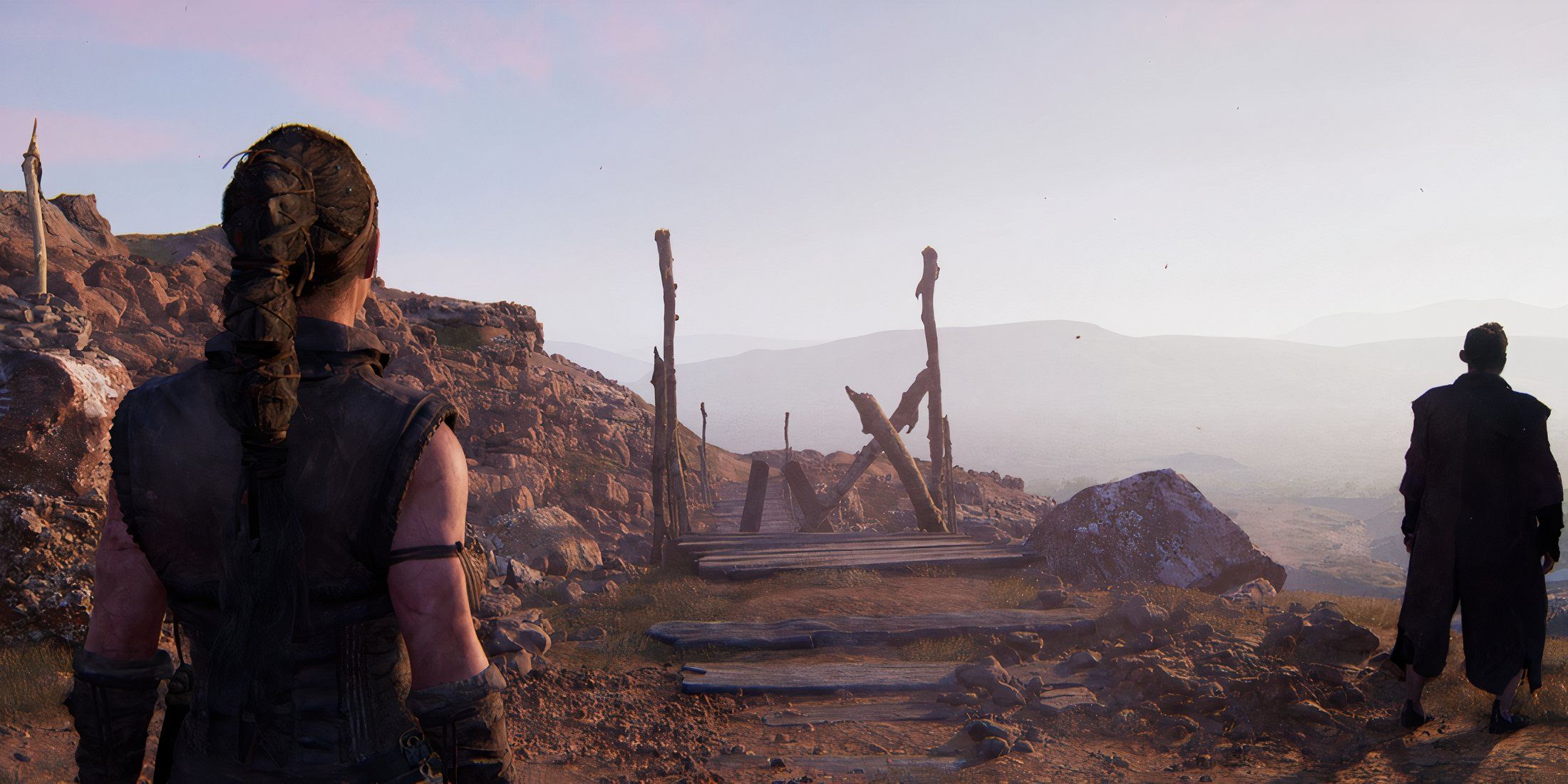 Senua standing in front of a broken bridge in Hellblade 2