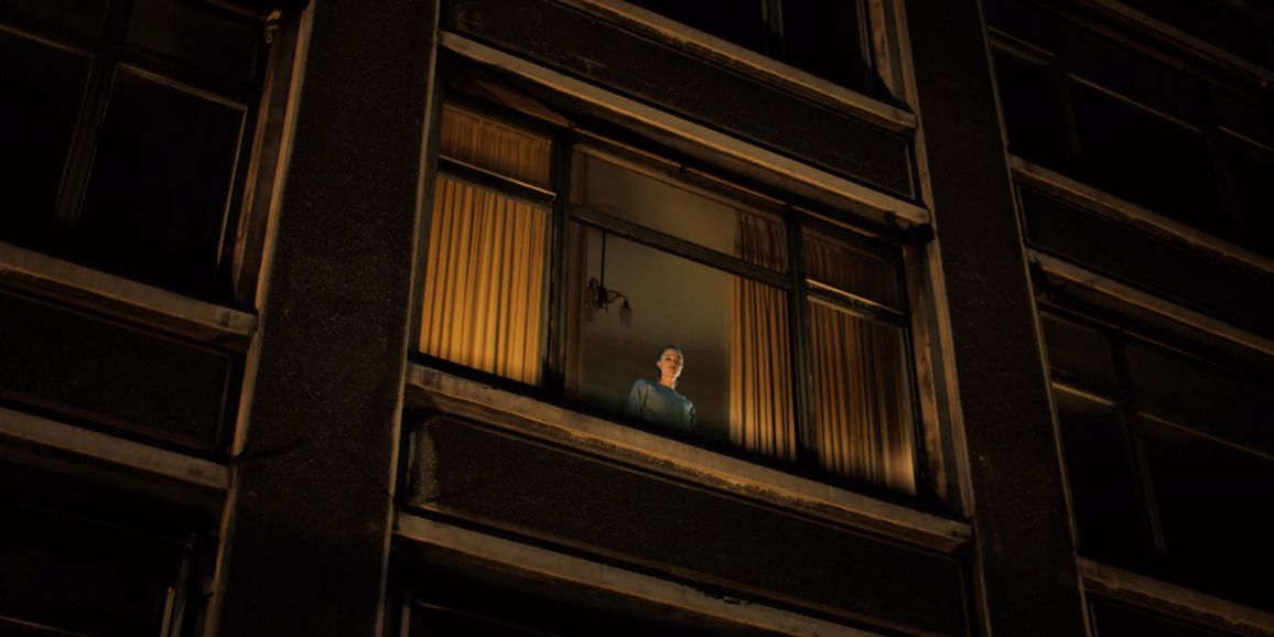 Watcher film still, woman looking down from window