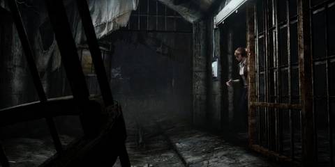 Claire stepping out from a prison cell in a. dark prison 