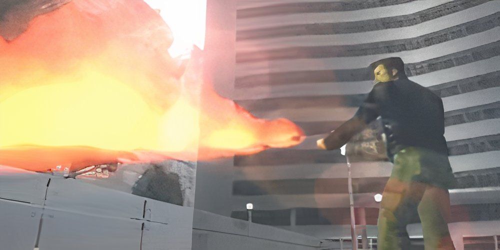 Man firing a flamethrower into a building 