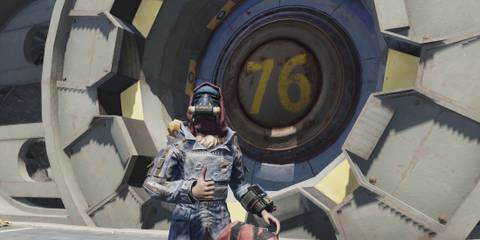 Fallout 76 Player Thumbs Up Emote in front of Vault 76 Door wearing Blue Ridge Caravan Outfit Milepost Zero Update September 3 GAMERANT custom image