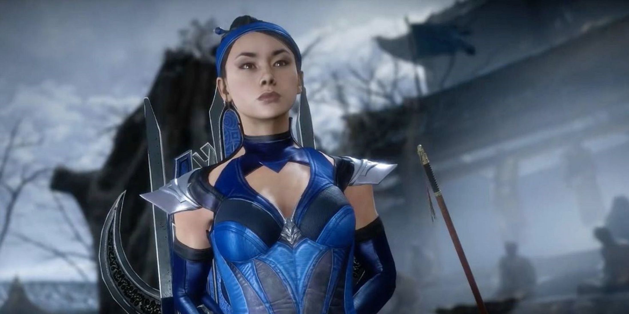 Kitana from Mortal Kombat standing confidently in her iconic blue outfit