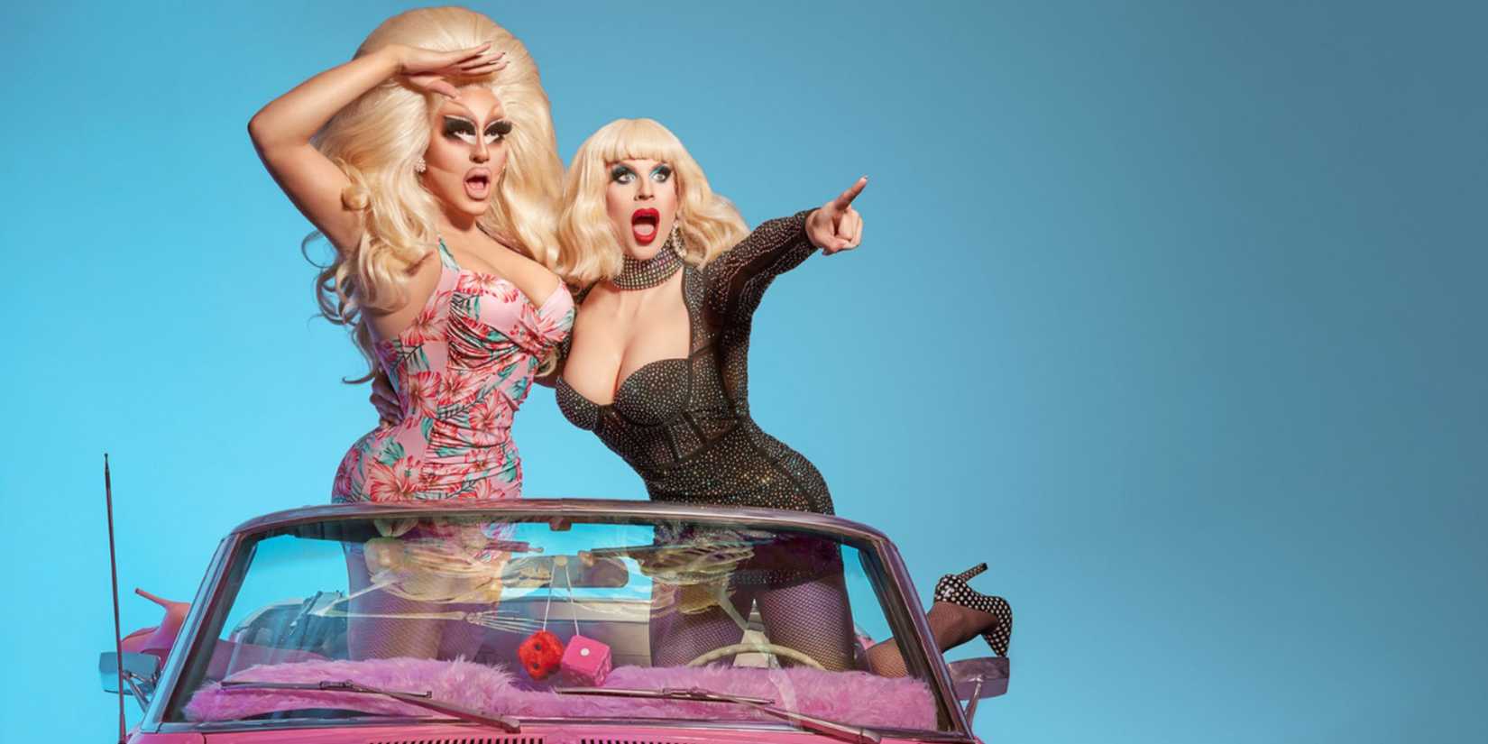 Trixie Mattel and Katya pointing to the distance in a pink car