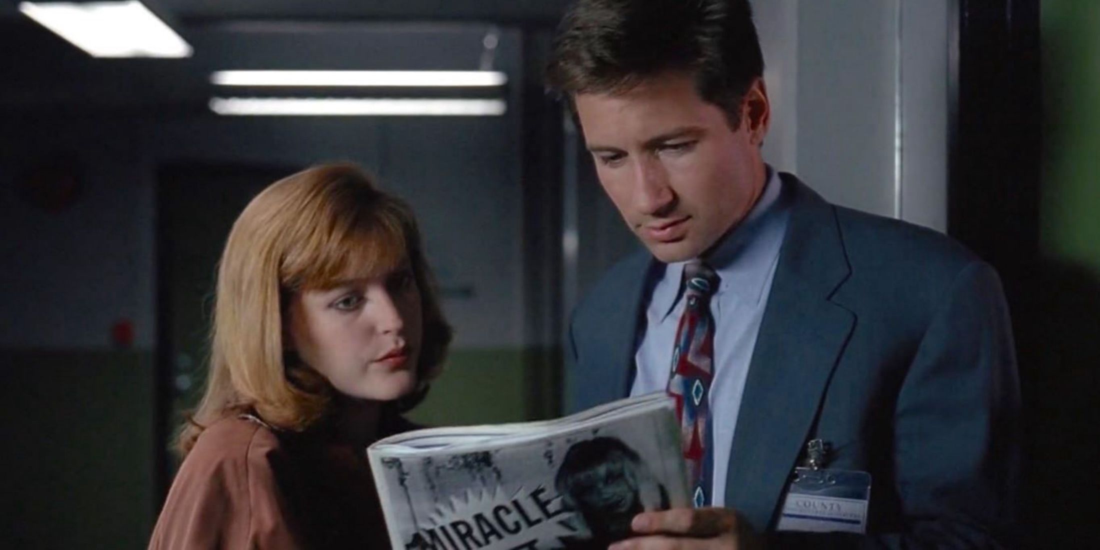 Mulder and Scully looking at a newspaper in the x-files