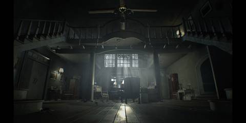 The Baker House main entry hall featuring living room furniture and a large ceiling fan