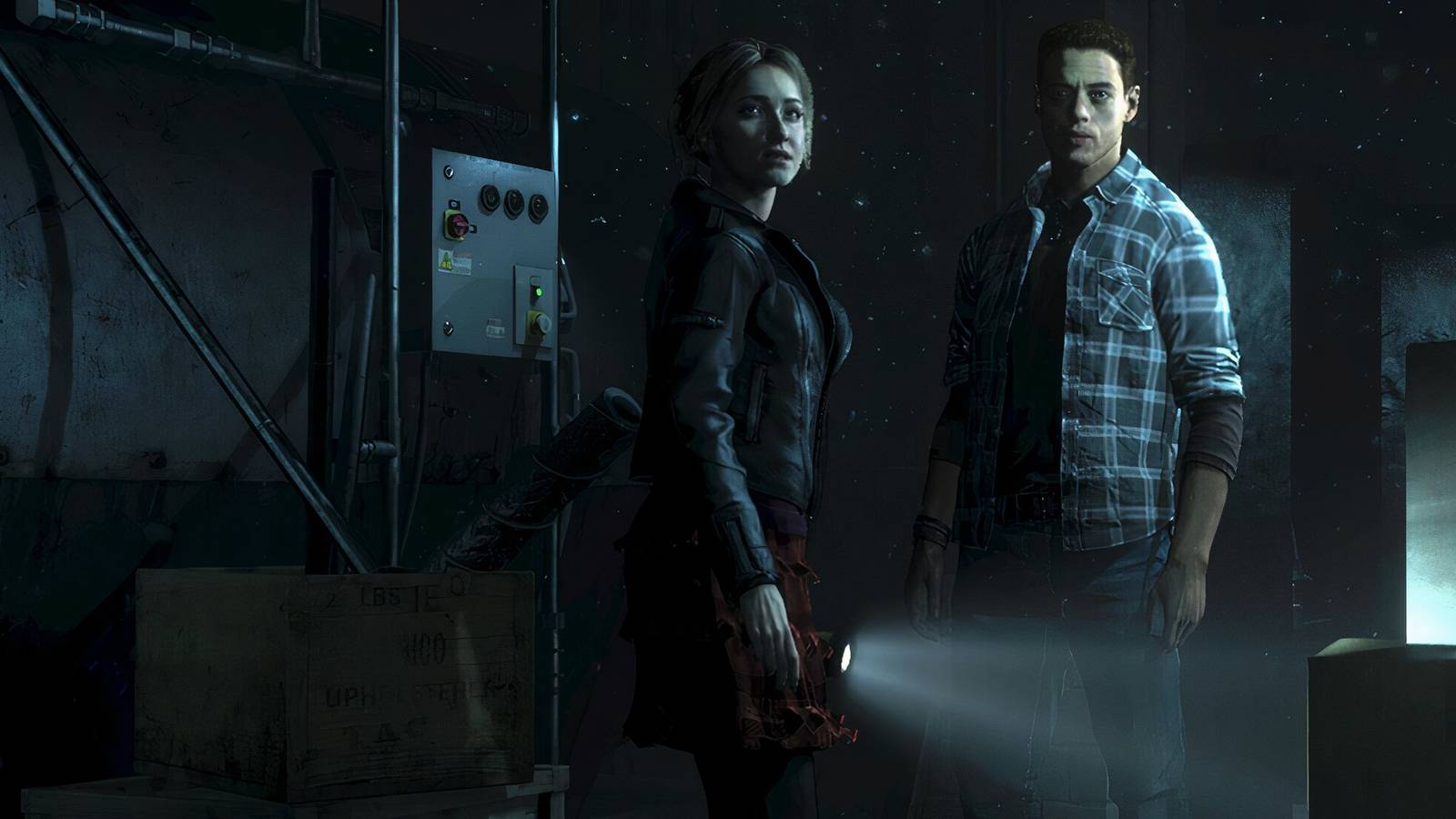 Sam and Josh standing in a dimly lit basement