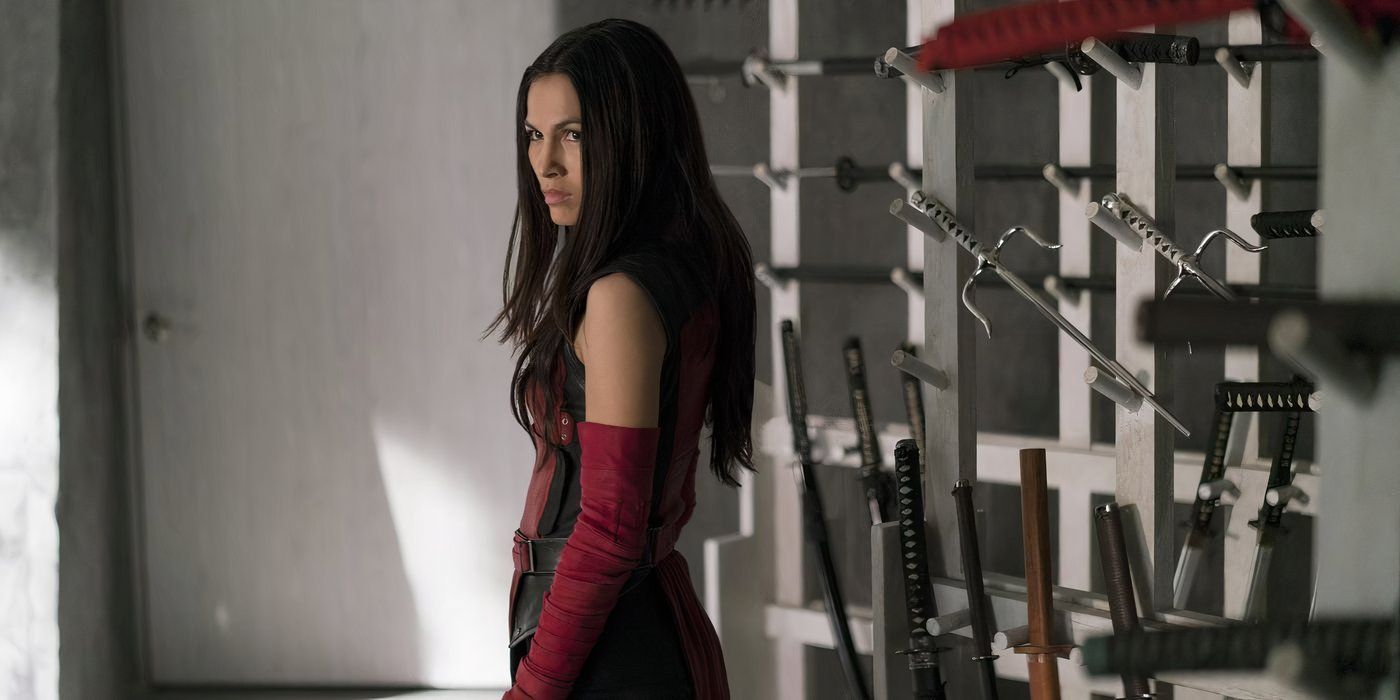 Elektra with a pile of weapons behind her