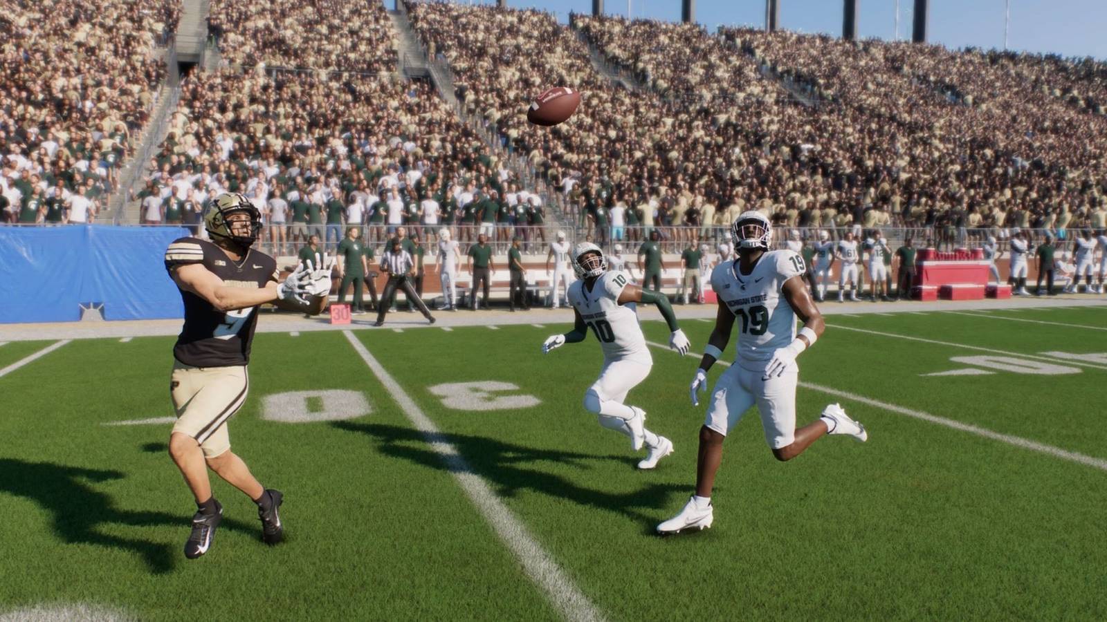 A player about to catch a pass in College Football 25 while being chased by defenders
