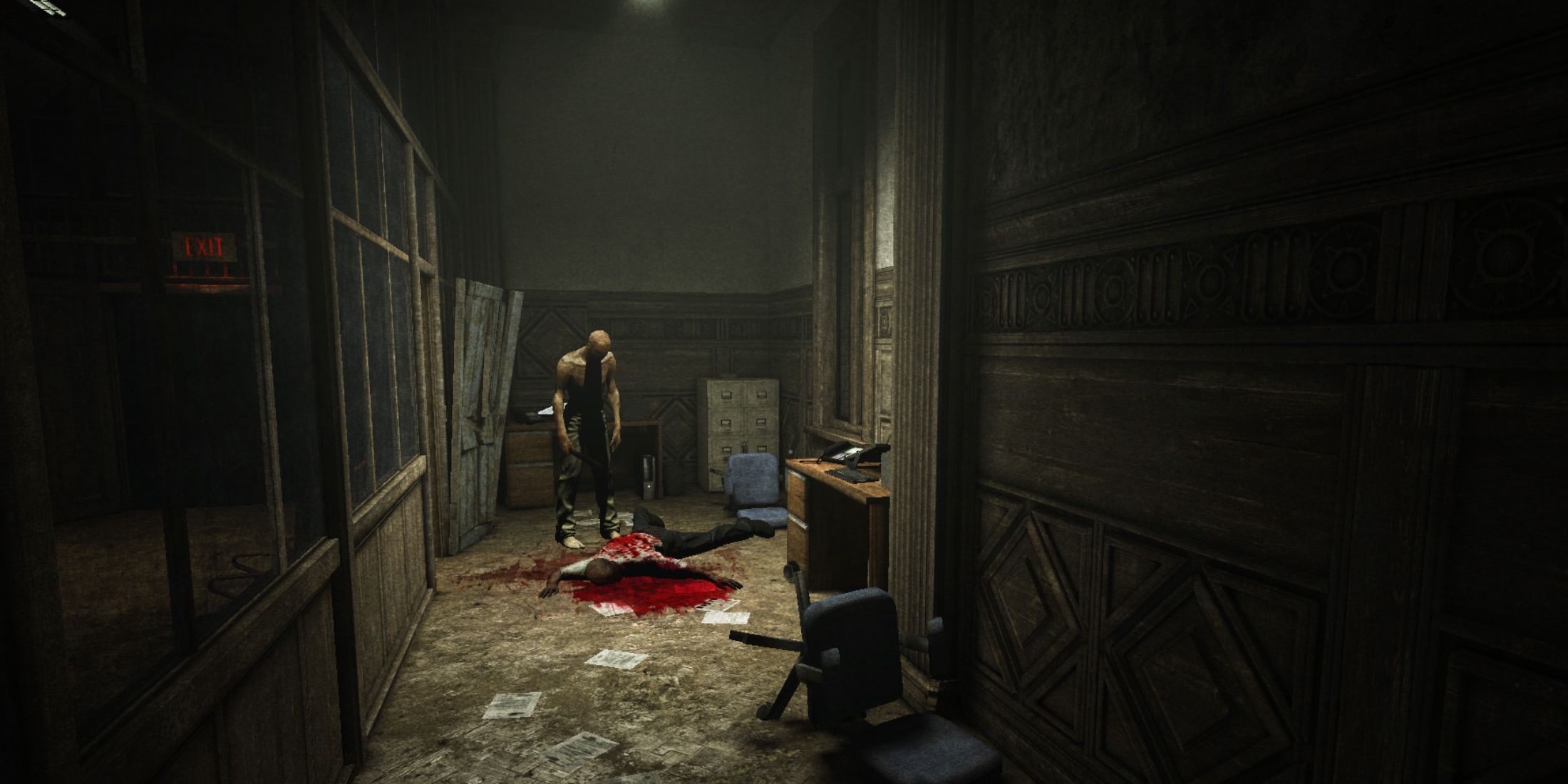 A man stands over a dead body in an office hallway in Outlast