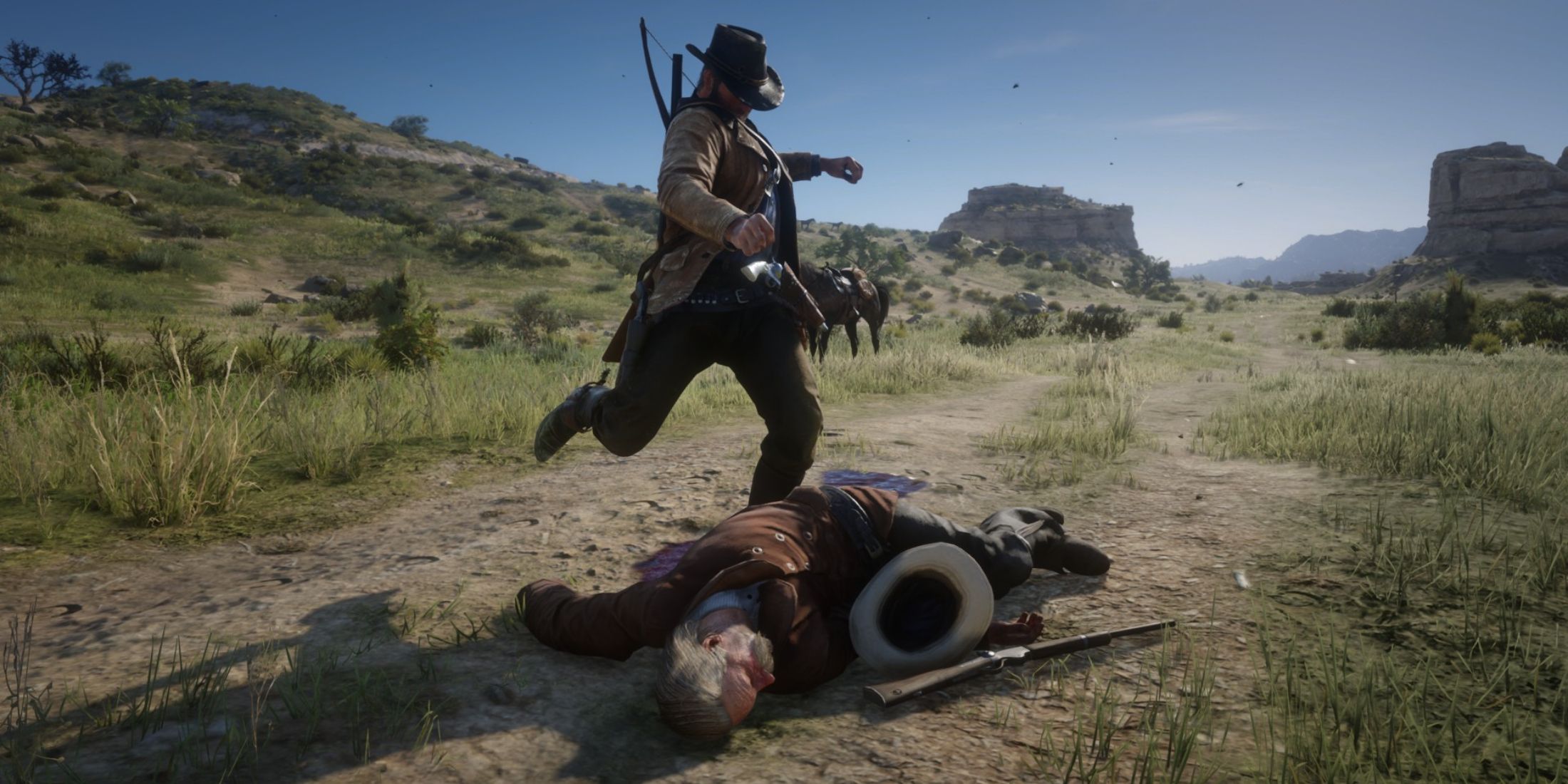 Arthur Morgan from Red Dead Redemption 2 kicks the body of a law enforcement officer.