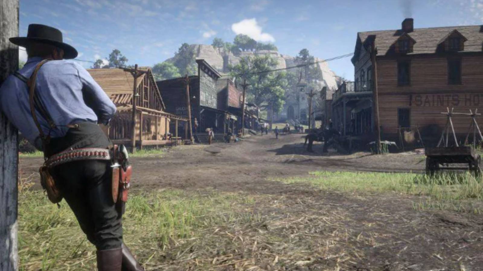 Arthur leaning against a post in a town called valentine in red dead redemption 2 