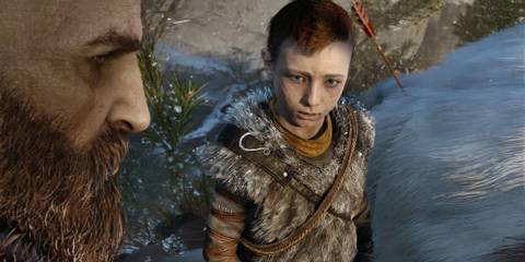 Atreus looking up at Kratos in God of War 2018