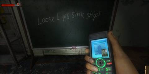 The player holding a phone in front of a chalkboard with a cryptic quote written on it