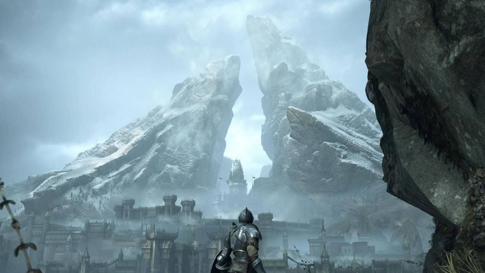 A knight in armor in front of a towering fortress framed by massive stone in Demon's Souls
