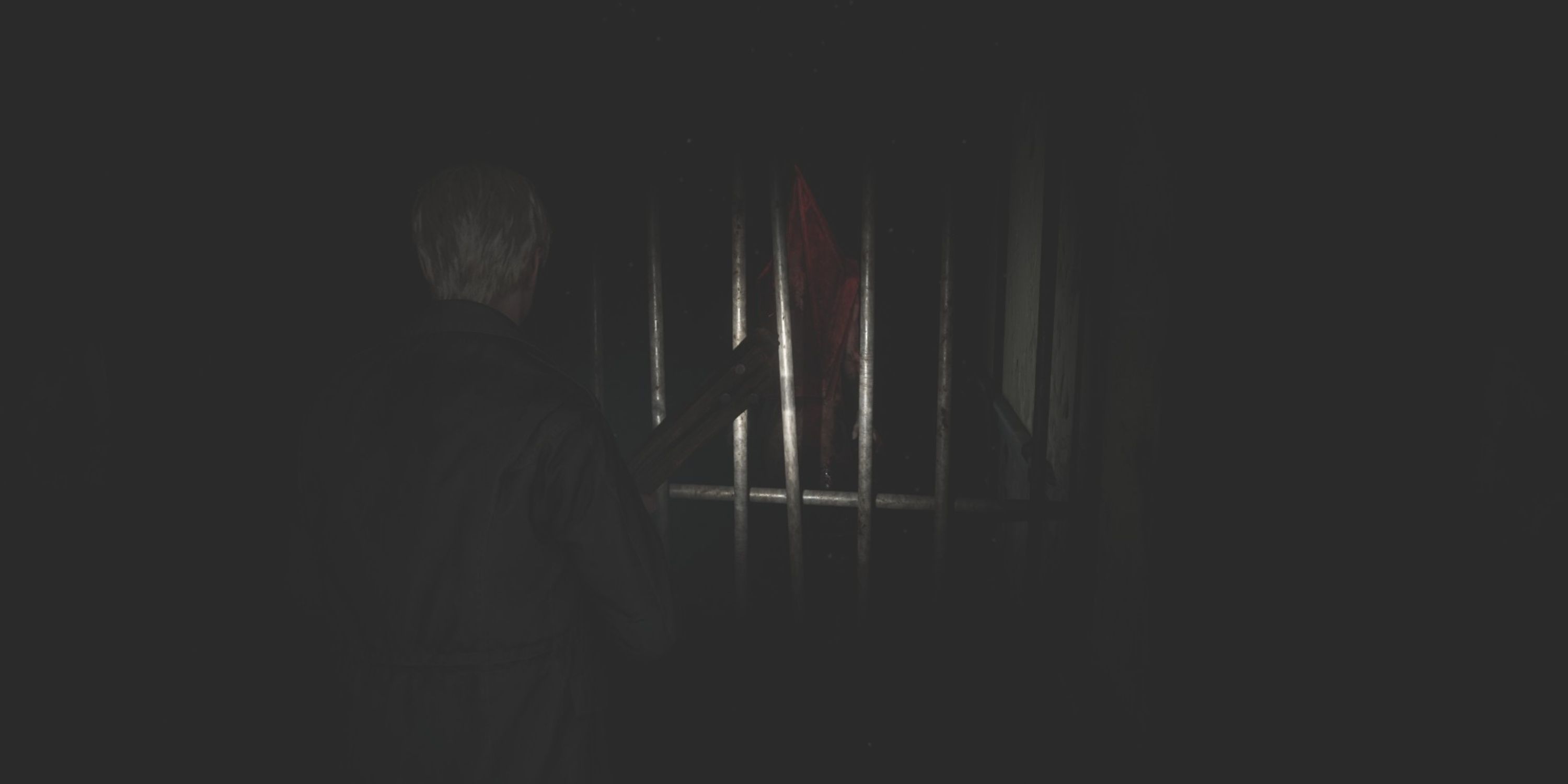 james sees pyramid head through some metal bars