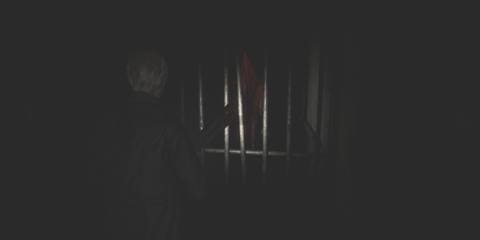 james sees pyramid head through some metal bars