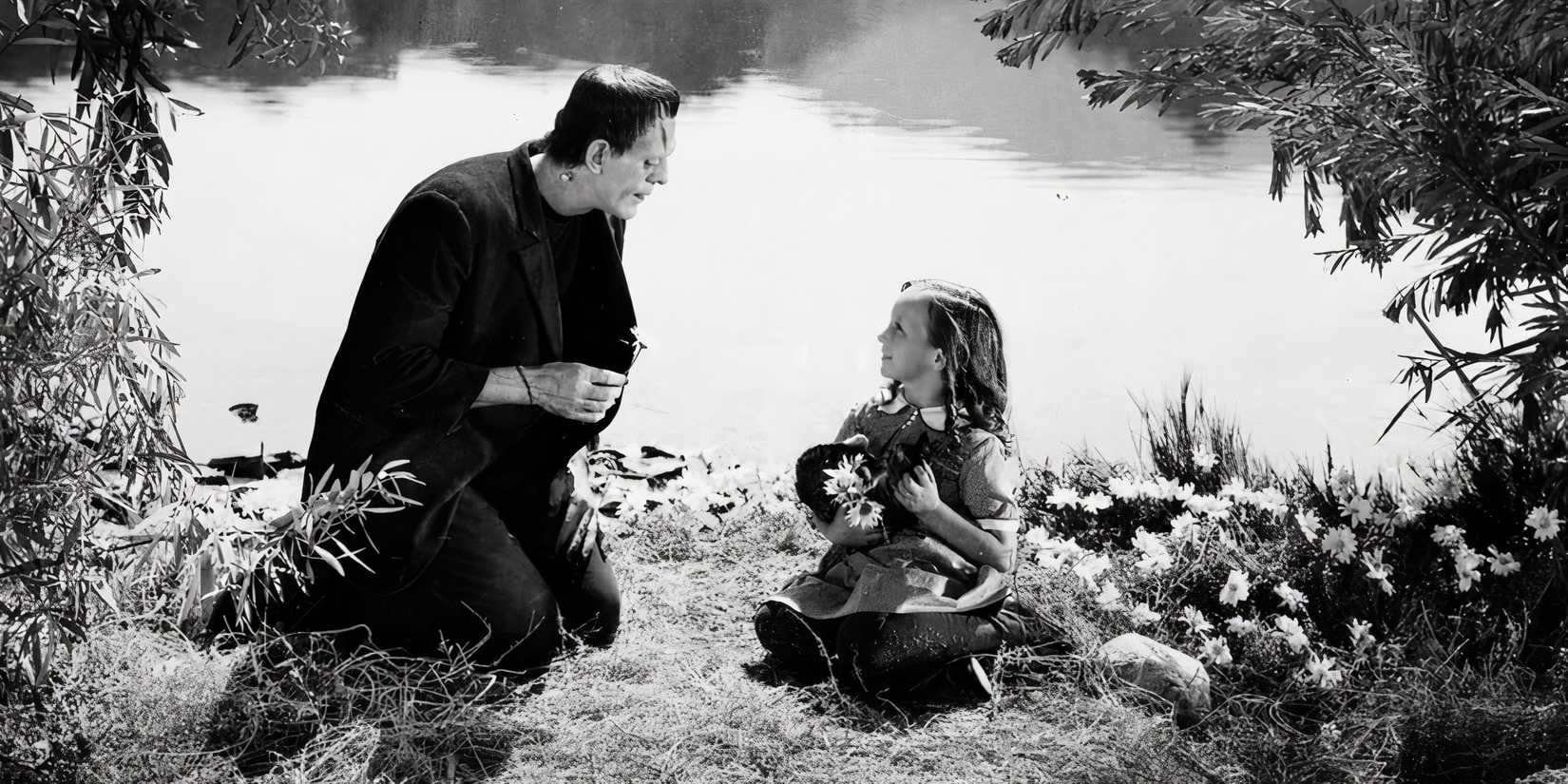 the creature and a little girl sit by a lake