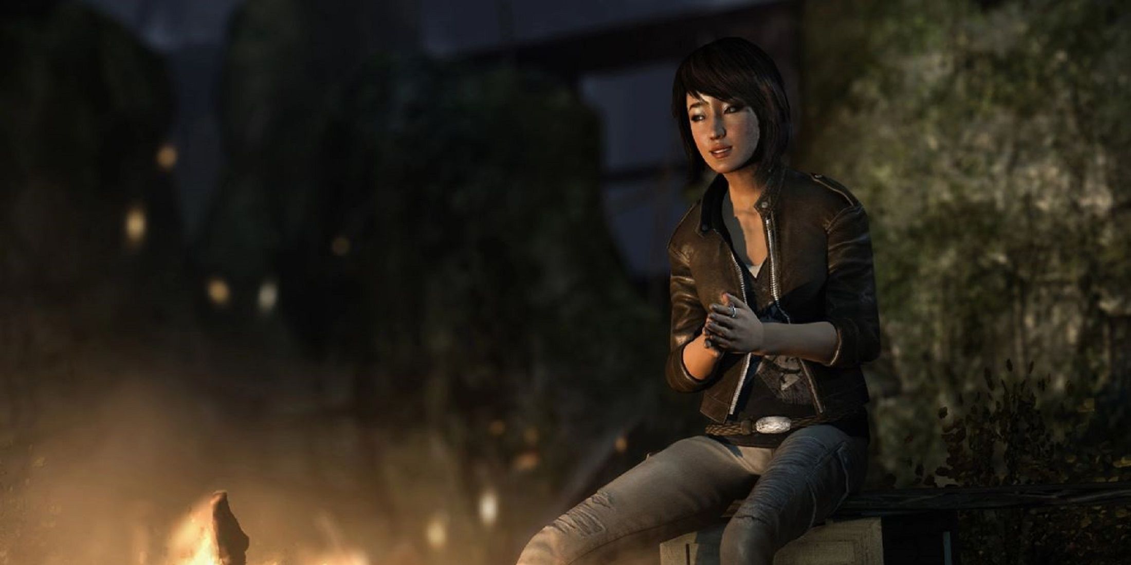 Samantha Nishimura from Tomb Raider sits beside a fire